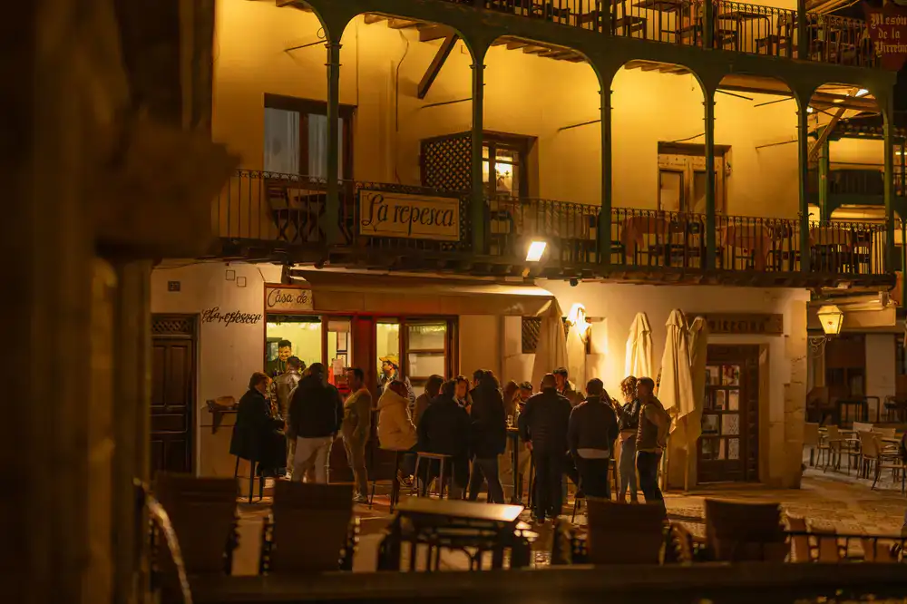 Invitados sonriendo y charlando alrededor de una estación de paella
