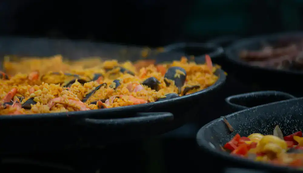 Chef cocinando paella gigante en evento al aire libre